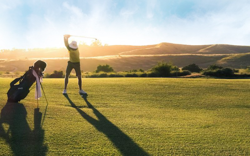 a couple of people playing golf in a field