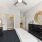 Large bed with a black dresser and s couple lamps