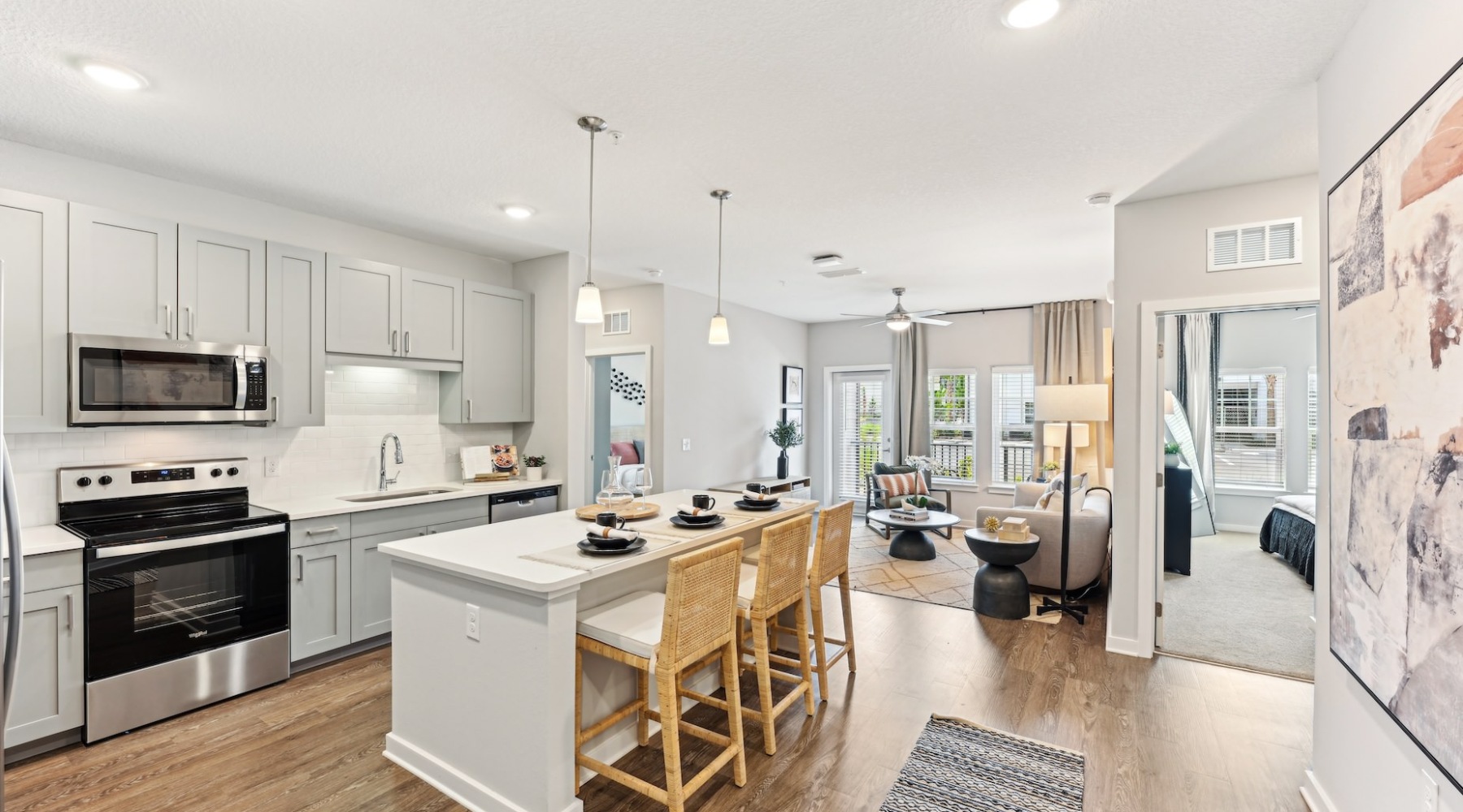 Modern apartments with spacious floorplans Kitchen island with hanging light fixture connected to a living room