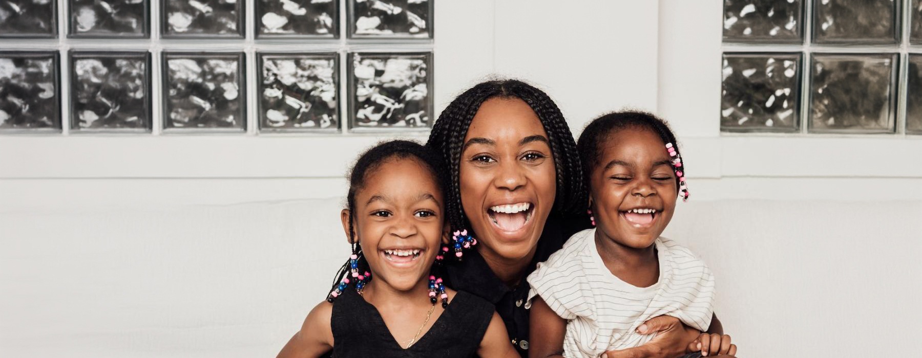 a woman sitting on a couch with two kids